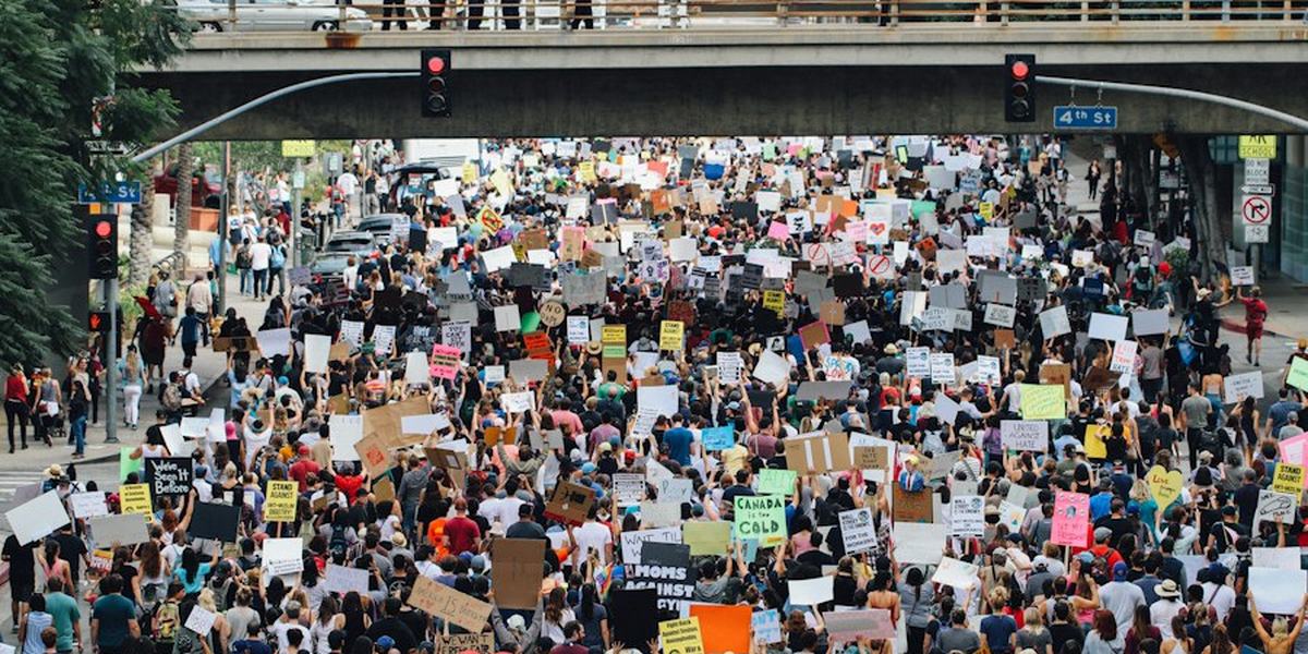 A dense crowd of marchers filling a city street