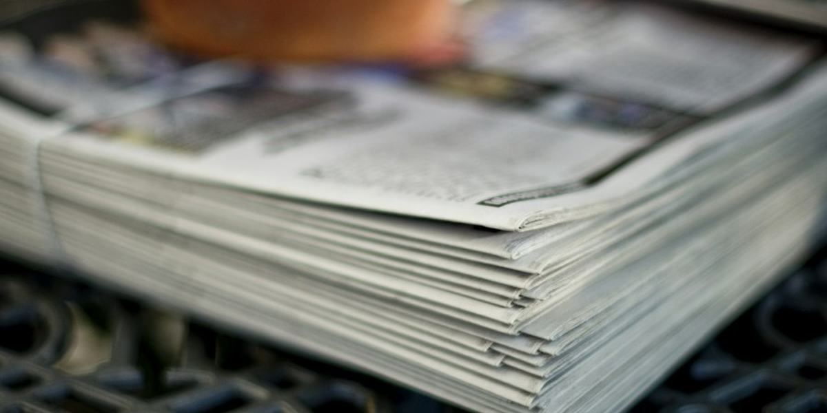 A stack of folded newspapers seen edge on