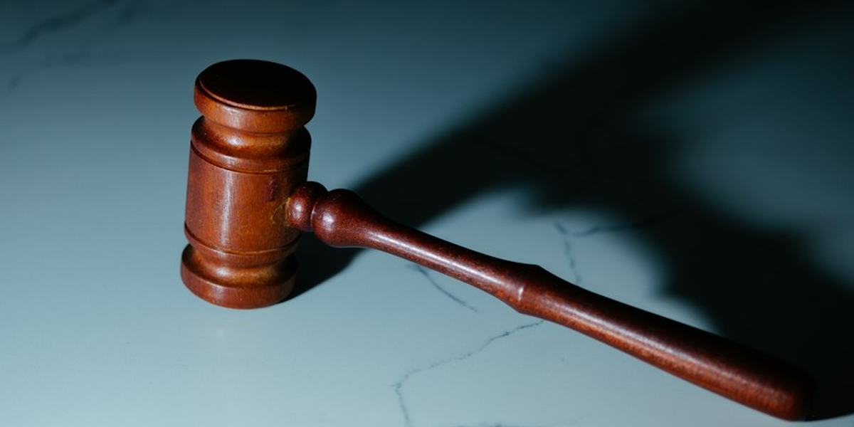 A wooden gavel resting on a dark surface
