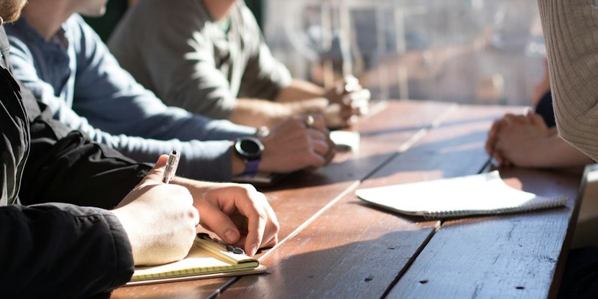 People taking notes around a meeting table