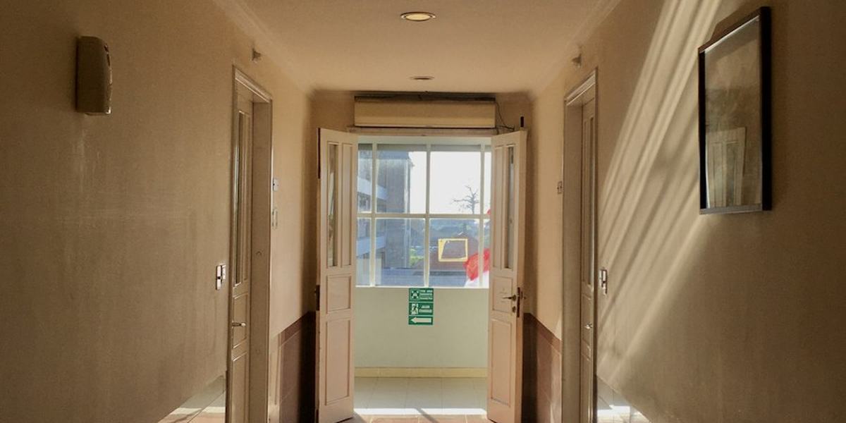A quiet hospital corridor with a doorway at the end