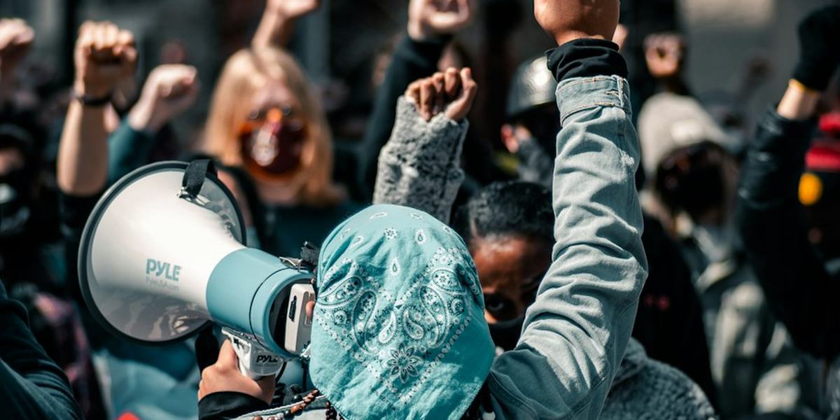 A protester speaking through a megaphone in a crowd