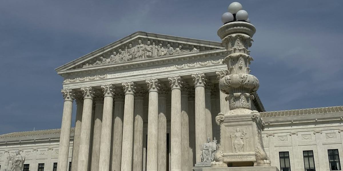 A courthouse facade with columns and a statue