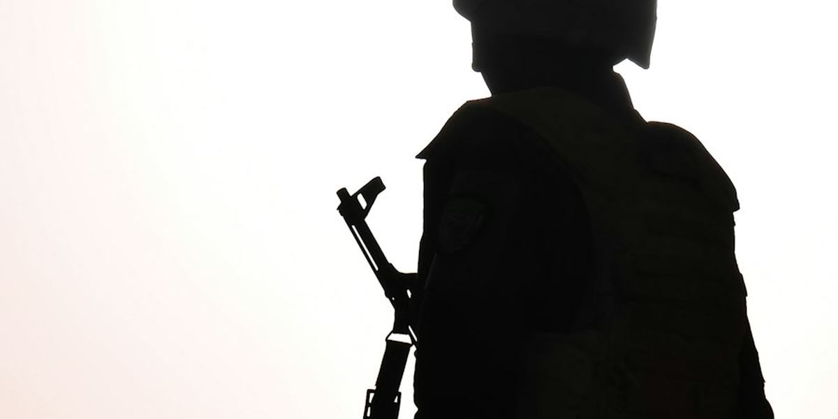 The silhouette of a soldier carrying a rifle
